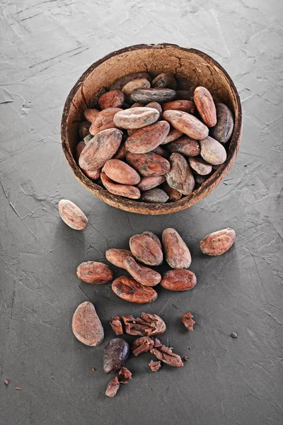 Rustic style image of cocoa beans in coconut shell bowl — Stock Photo, Image