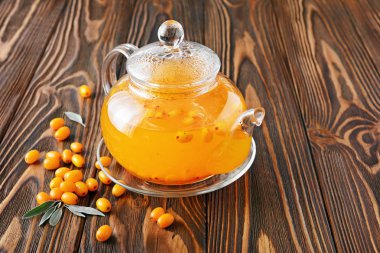 Deniz cehri çay ahşap arka plan üzerinde taze çilek ile cam çaydanlık