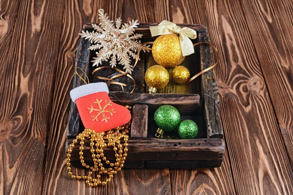 Caja de sombras vintage con bola de Navidad dorada y verde sobre fondo de madera — Foto de Stock