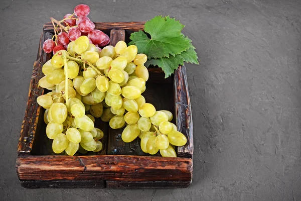 Zdravé jídlo. Detailní pohled banda zelené a růžové hroznů v retro dřevěný box — Stock fotografie