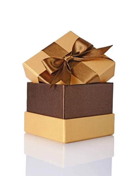 Klasické zlaté lesklé krabičky s hnědou saténovou mašlí — Stock fotografie