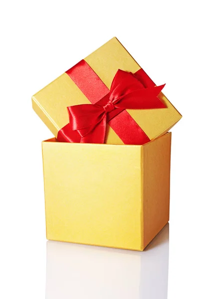 Golden classic shiny gift box with red satin bow — Stock Photo, Image
