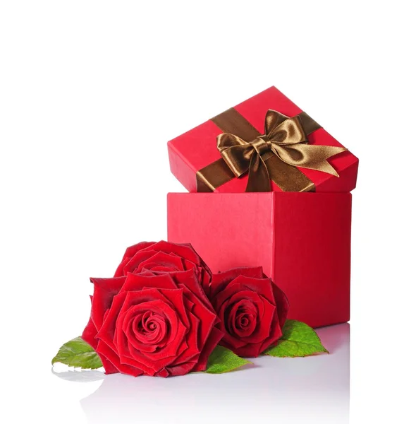 Klassische Geschenkbox mit brauner Satinschleife und Strauß roter Rosen — Stockfoto