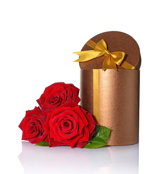 Bronze classic shiny round gift box with golden satin bow and bouquet of roses — Stock Photo, Image