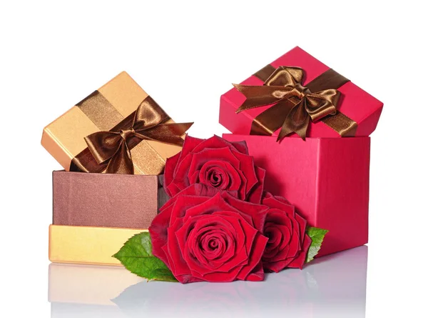 Golden and red classic shiny gift boxes with brown satin bows and bouquet of roses — Stock Photo, Image