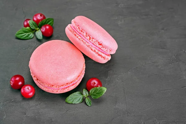 French dessert. Sweet pink macaroons or macarons with cranberry and mint