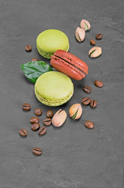 Postre francés. Macarrones o macarrones de chocolate dulce y pistacho con granos de café y nueces —  Fotos de Stock