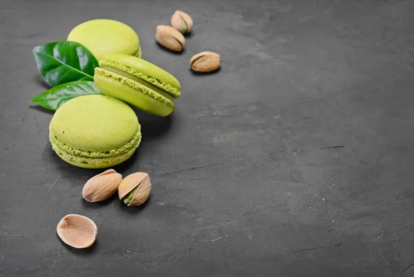 French dessert. Sweet green pistachio flavor macaroons or macarons with nuts and leaves