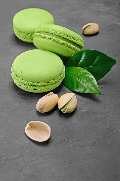 French dessert. Sweet green pistachio flavor macaroons or macarons with nuts and leaves