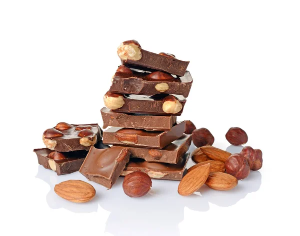 Close-up pieces of chocolate bar with whole hazelnuts and almonds — Stock Photo, Image