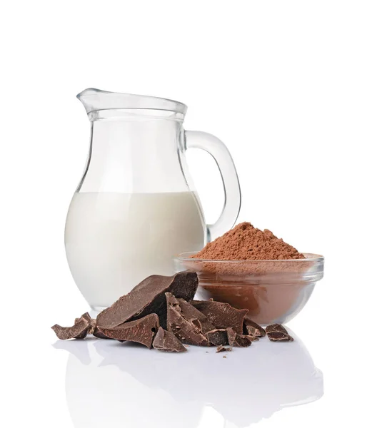 Close-up pieces of chunk black chocolate with glass bowl of cocoa powder and jug of milk — Stock Photo, Image