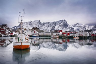 Beautiful winter landscape of harbor with fishing boat and traditional Norwegian rorbus clipart