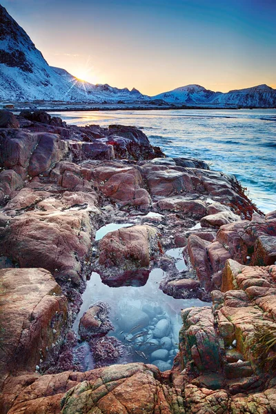 Beautiful sunset Norway landscape of picturesque stones on the arctic beach of cold Norwegian Sea