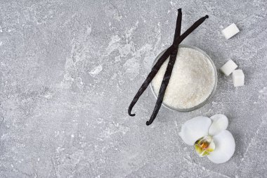 Bir çiçek ve gri beton zemin üzerine pişirme için madde olarak şekerli vanilya pods