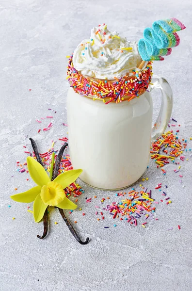 Crazy vanilla milk shake with whipped cream and colored candy in glass jar — Stock Photo, Image