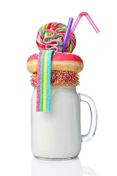 Crazy milk shake with pink donut, color candy and lollipop in glass jar — Stock Photo, Image