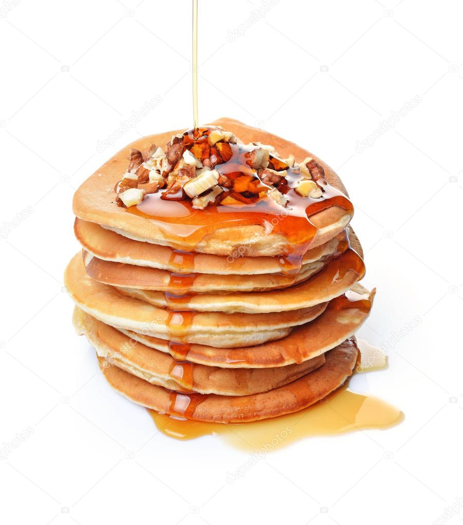 Tasty breakfast. Homemade pancakes with crushed hazelnut, honey or maple syrup isolated on white background