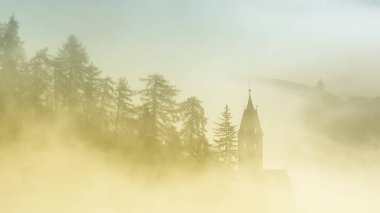 Dolomites dağlarındaki kilisenin mistik sisli manzarası