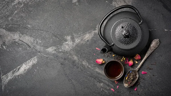 Tetera de hierro fundido japonés negro y té de flores con capullos de rosa — Foto de Stock
