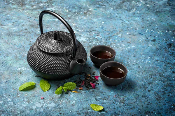 Černá japonská litinová konvice s čajem a čerstvým mátou — Stock fotografie