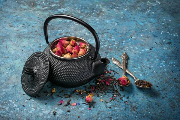 Svart japansk gjutjärn tekanna och blomma te med rosenknoppar — Stockfoto