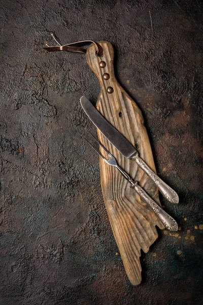 Tenedor y cuchillo de plata vintage sobre tabla de madera —  Fotos de Stock
