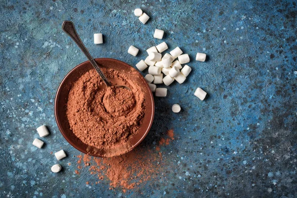 Cocoa powder in brown bowl with silver spoon and white marshmallow — Stock Photo, Image