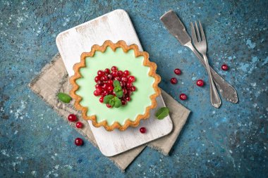 Delicious mint tart with fresh cranberry and vintage silverware