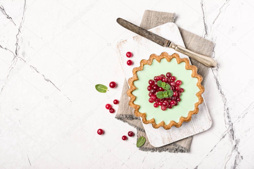 Delicious mint tart with fresh cranberry and vintage knife