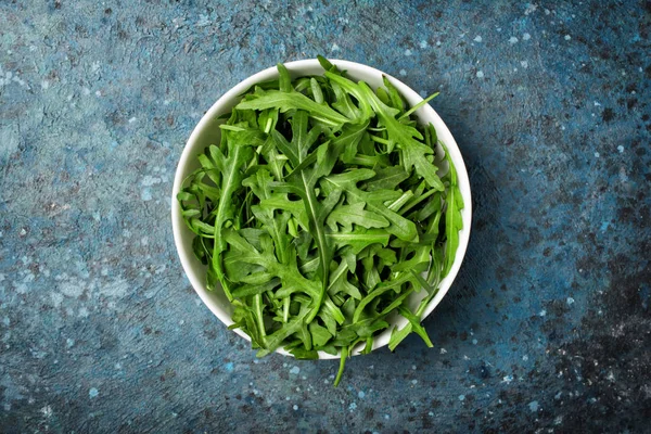 Vista Superior Salada Rúcula Vegetariana Fundo Concreto Azul — Fotografia de Stock