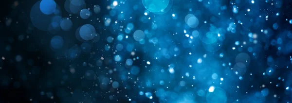 Banner of defocused blue circles with magic bokeh effect on black background