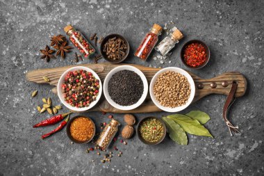 Parlak baharat ve otları küçük kâse ve şişede karıştırmanın en iyi yolu gri beton arka plandaki sağlıklı yiyecekler için malzeme olarak kullanmaktır.