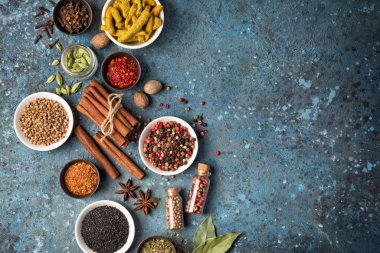 Parlak baharat ve otları küçük kâse ve şişede karıştırmanın en iyi yolu mavi beton arka planda sağlıklı yiyecekler ve fotokopi alanı oluşturmaktır.