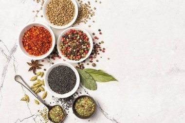 Parlak baharat ve bitkilerin beyaz mermer arka planda ve fotokopi alanındaki sağlıklı yiyecekler için malzeme olarak küçük kâselerde karıştırılmasının üst görüntüsü