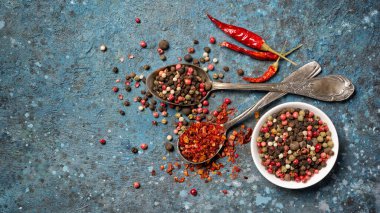 Parlak baharatları kaliteli gümüş kaşıkla karıştırmanın en iyi yolu mavi beton arka planda sağlıklı yiyecekler ve kopyalama alanı içermesidir.