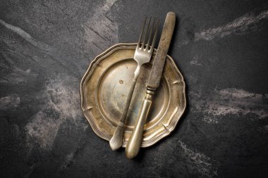 Antika gümüş kaplama çatal bıçak takımının ya da siyah mermer arka plandaki gümüş çatal bıçak takımının üst görüntüsü