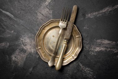 Antika gümüş kaplama çatal bıçak takımının ya da siyah mermer arka plandaki gümüş çatal bıçak takımının üst görüntüsü