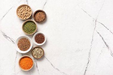 Mercimek, fasulye, nohut, karabuğday, pirinç ve kinoa karışımı beyaz mermer arka planda fotokopi alanı ile karıştırılmış.