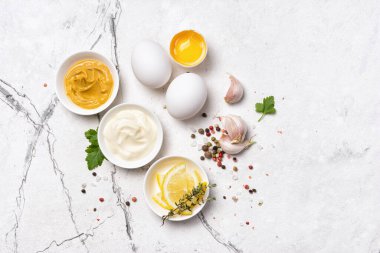 Ev yapımı mayonez malzemelerinin beyaz mermer arka planda hardal, yumurta, baharat olarak üst görünümü