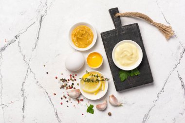 Ev yapımı mayonezin içeriğinin en üst görüntüsü hardal, yumurta, beyaz mermer arka planda baharatlar ve fotokopi alanı.