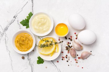 Ev yapımı mayonez malzemelerinin beyaz mermer arka planda hardal, yumurta, baharat olarak üst görünümü
