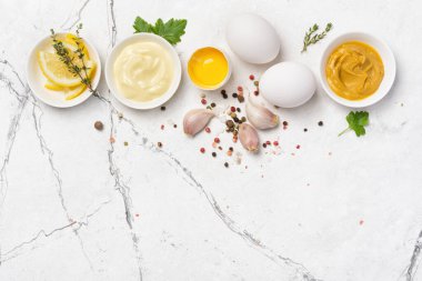 Ev yapımı mayonezin içeriğinin en üst görüntüsü hardal, yumurta, beyaz mermer arka planda baharatlar ve fotokopi alanı.
