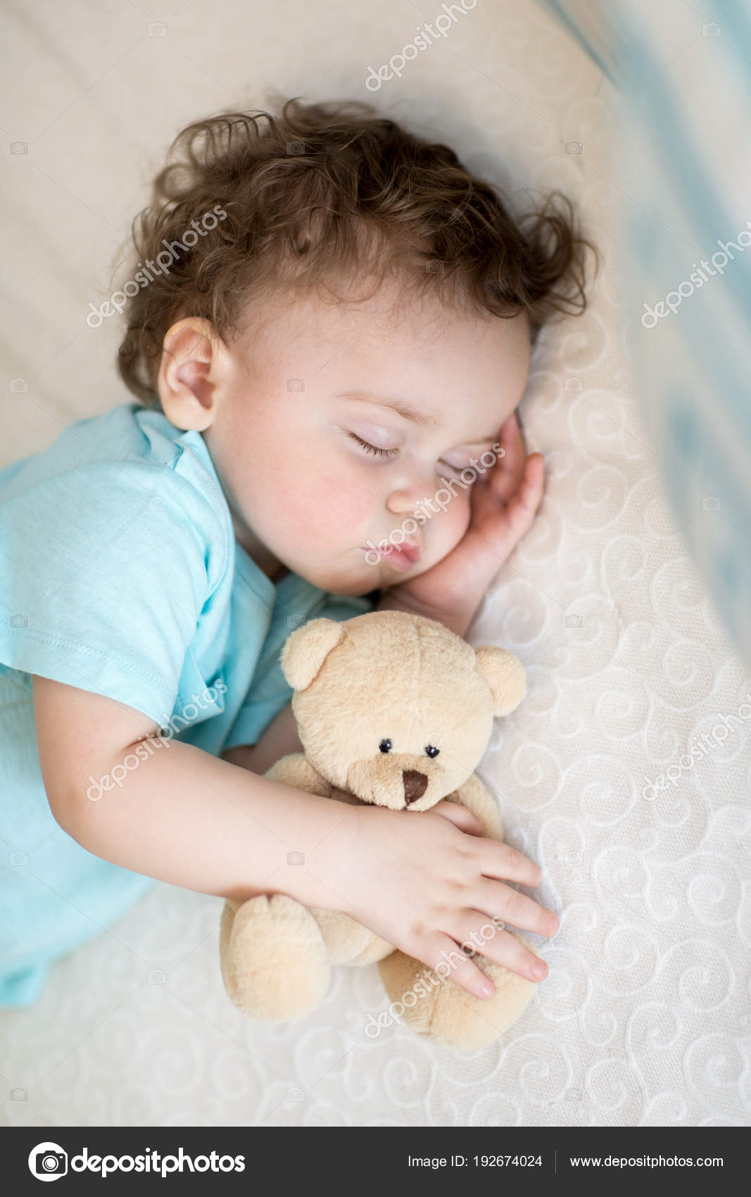 baby holding teddy bear