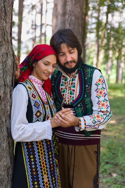 Ζευγάρι στο βουλγαρικό παραδοσιακό φόρεμα σε ένα σύμπλεγμα δομών — Φωτογραφία Αρχείου