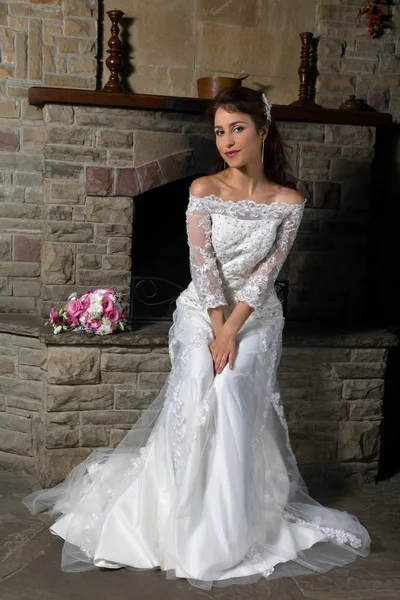 Bride sitting in front of fireplace — Stock Photo, Image