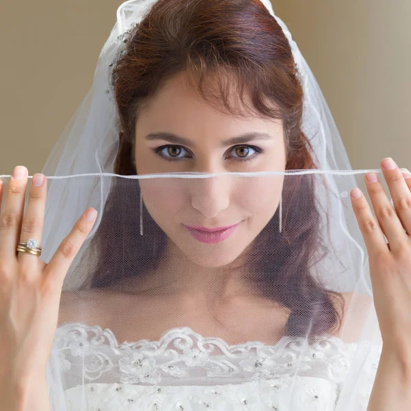 Happy bride looking through sheer veil — Stock Photo, Image