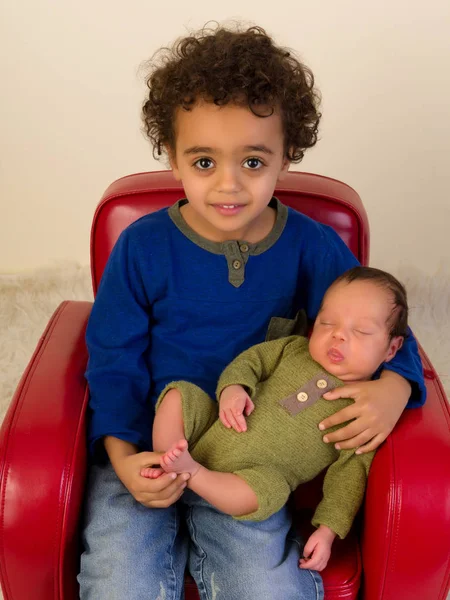 Улыбающийся брат с новорожденным братом — стоковое фото