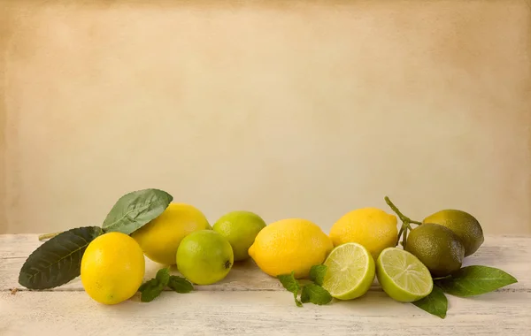 Lemons and limes on vintage table — Stock Photo, Image