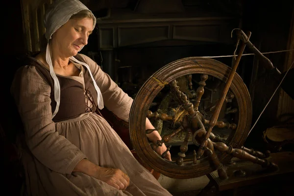 文艺复兴时期一位妇女的画像 她在壁炉前旋转着古老的纺车 — 图库照片