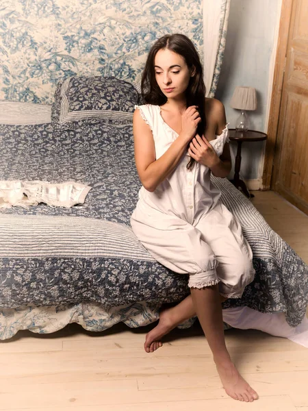 身着正宗维多利亚式灯笼裤和紧身衣的年轻女子 穿着古旧的睡房 头戴天篷床 — 图库照片